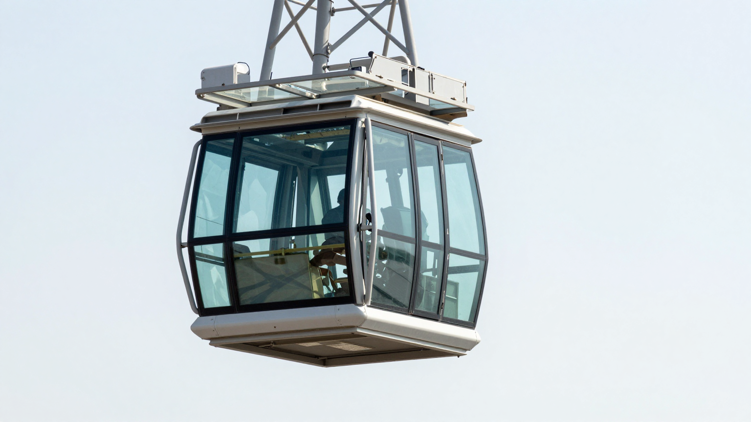 Crane operator cab suspended at height with full glass exposure to sun